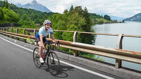Fay Manner riding a bike on a bridge in her “ride to steep lines” project